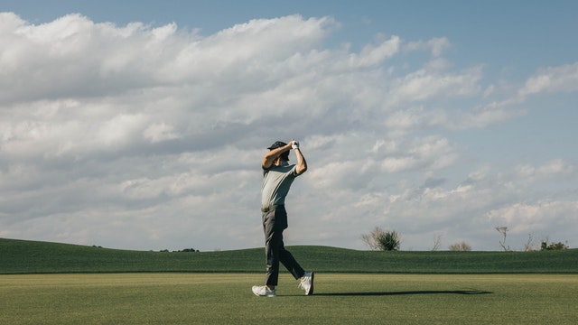 Male golfer in grey on top of swing Male golfer in grey on top of swing